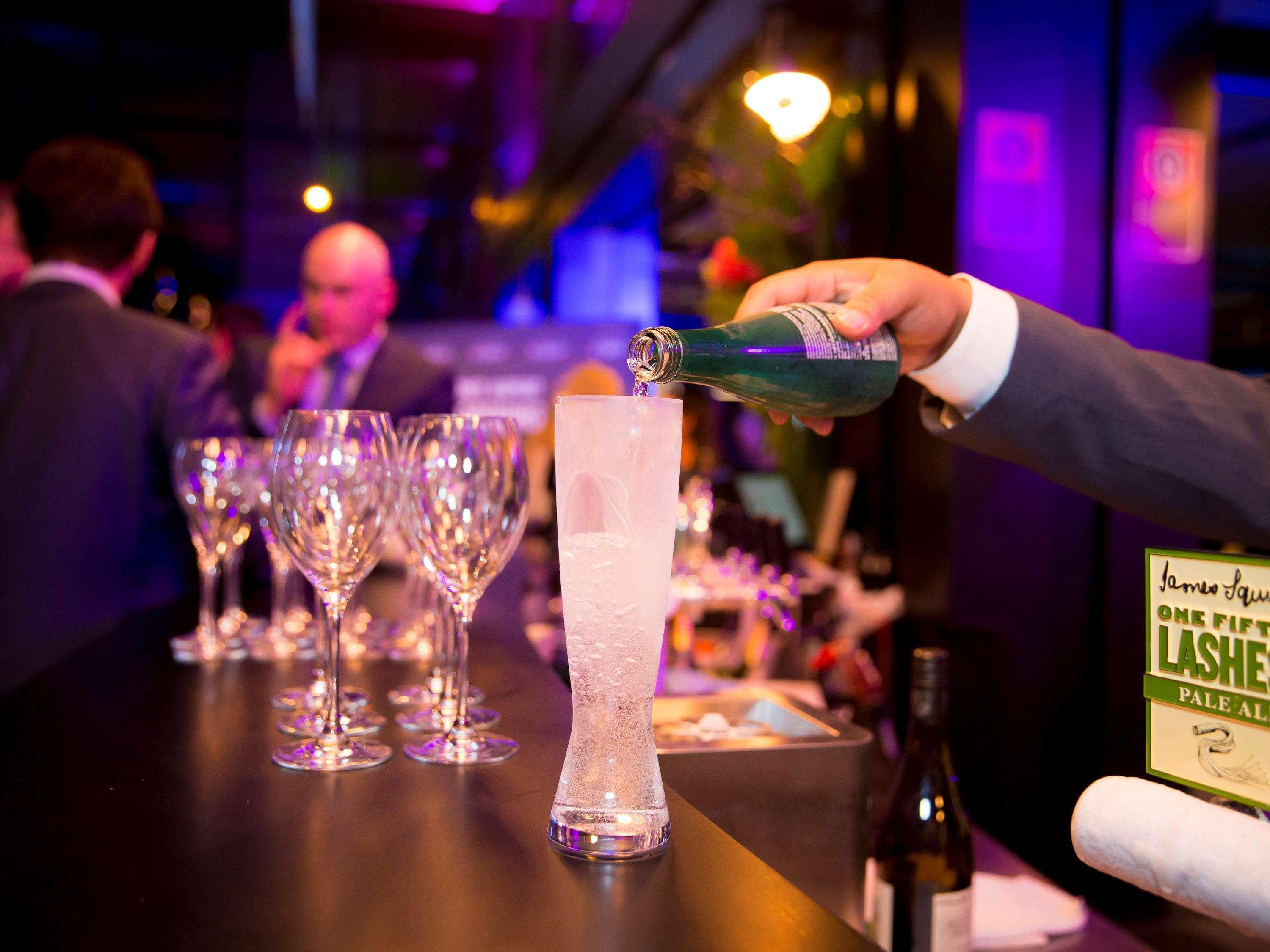 Pullman Sydney Airport Otel Dış mekan fotoğraf A bartender pouring champagne